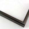 9/16 " slim, curved metal frame. This frame ranges in color from dark grey to purple-grey depending on the light source. It has a subtle heathered pattern and a smooth, polished texture.
Profile 21 has 1-1/8 " deep sides, and will hold artwork, mats, backing, and glazing up to a total of 5/8 ".
Nielsen Aluminum Moulding N21-256